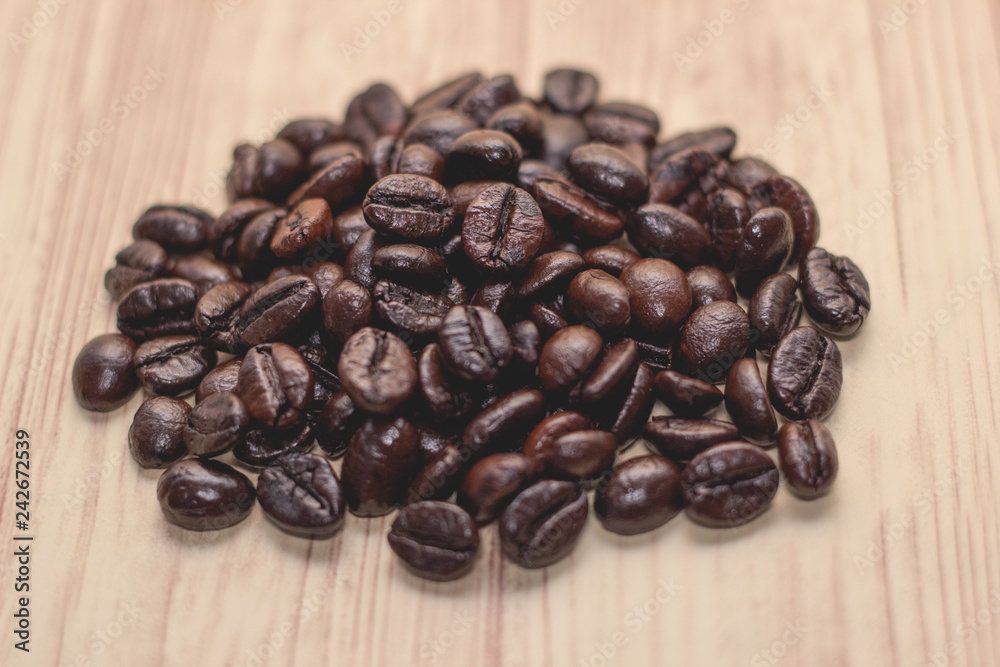 Roasted coffee beans on wood background