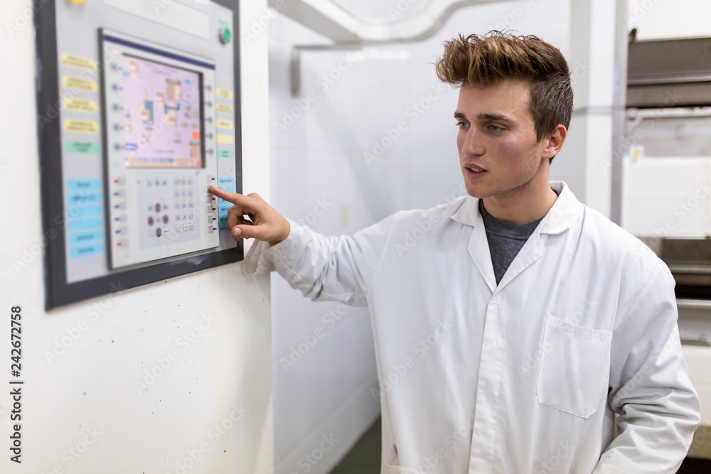 Young woman and young man checking production of oil in a control machine Young woman and young man checking production of oil in a control machine