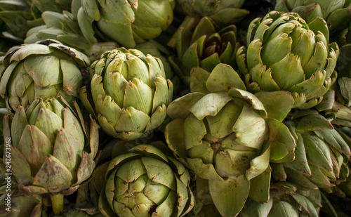 Close up of group fresh globe artichoke (Cynara cardunculus) at a farmers market. Healthy food. Organic background.