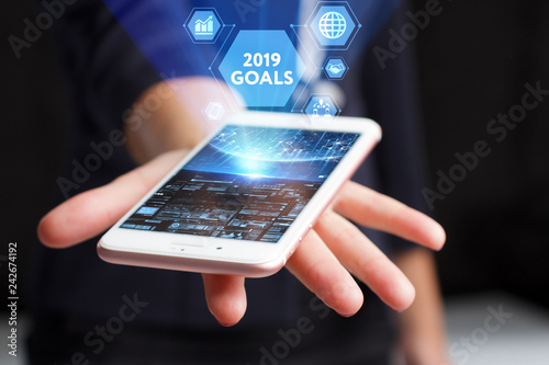 The concept of business, technology, the Internet and the network. A young entrepreneur working on a virtual screen of the future and sees the inscription: 2019 goals