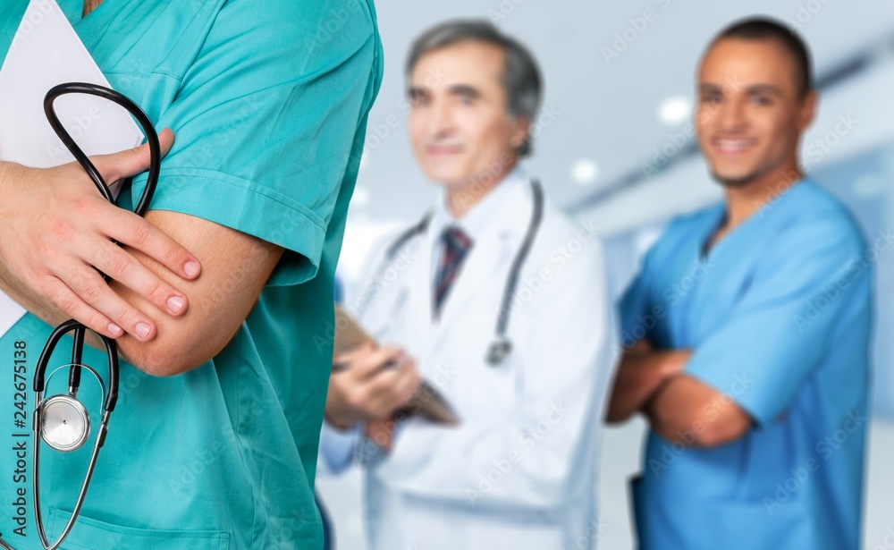 Male doctor with stethoscope on hospital background Male doctor with stethoscope on hospital background
