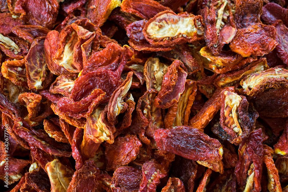 Close up of group of dried red tomatoes at a farmers market. Healthy food. Organic background
