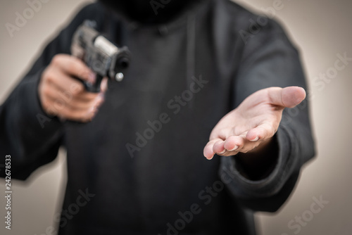 Gun and money in a hands. Bank robbery, Man carrying a gun to rob the money. To threaten with the gun man photo