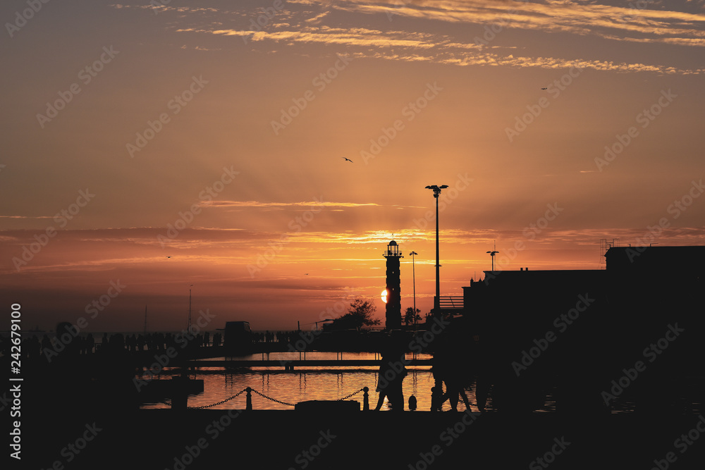 Beautiful sunset at Lisboa's port with the sun hidden in a lighthouse Beautiful sunset at Lisboa's port with the sun hidden in a lighthouse