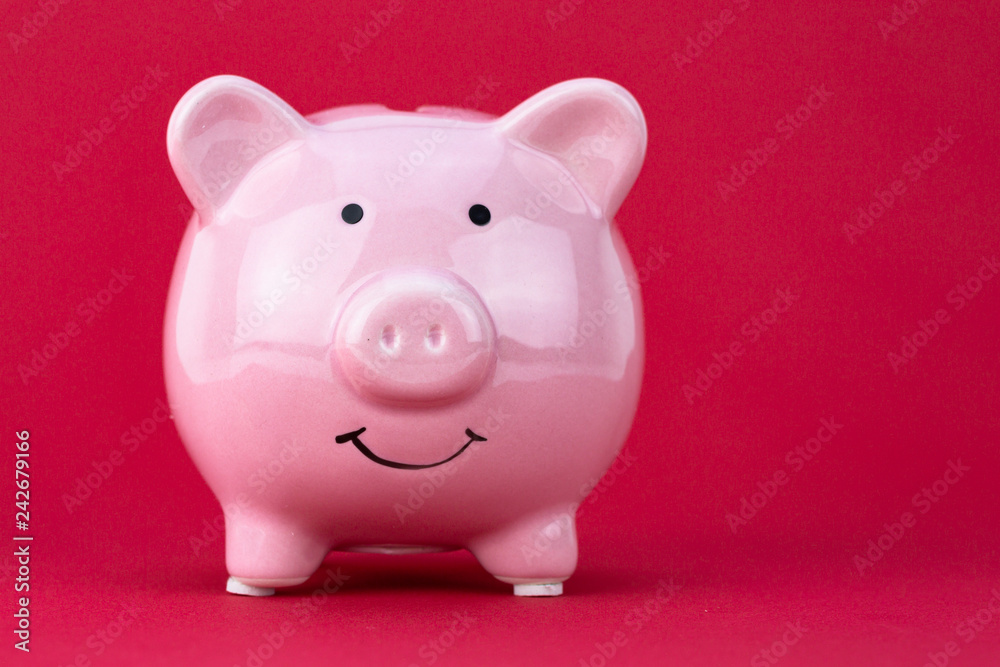 Piggy bank savings concept with raspberry color on background Piggy bank savings concept with raspberry color on background