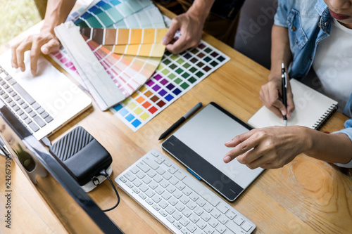 Team of young colleagues creative graphic designer working on color selection and drawing on graphics tablet at workplace, Color swatch samples chart for selection coloring