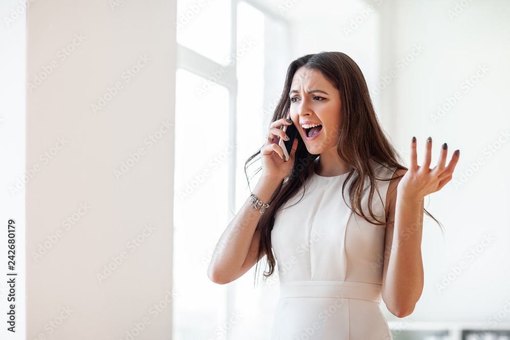 Angry beautiful woman screams in mobile phone Angry beautiful woman screams in mobile phone
