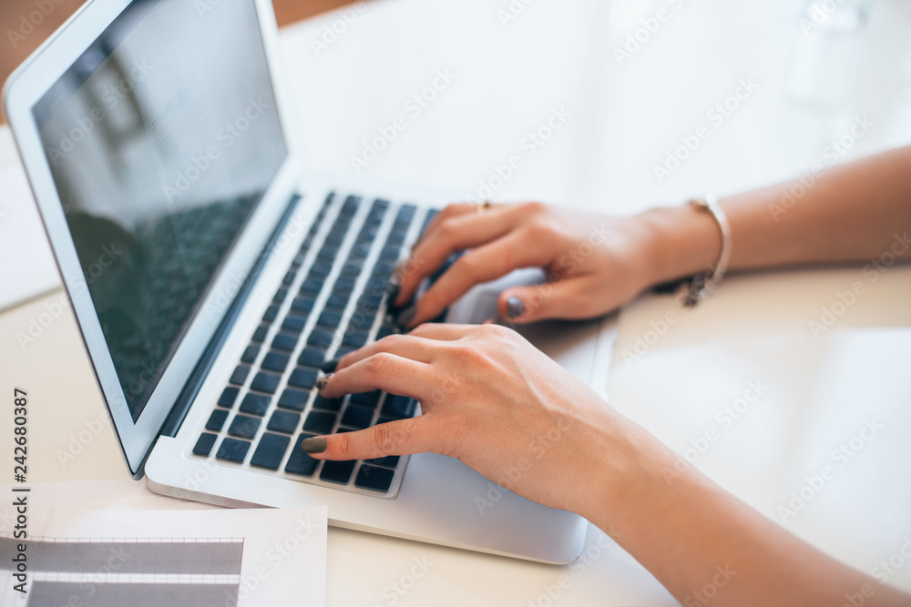 Female hands typing on a laptop keyboard Female hands typing on a laptop keyboard