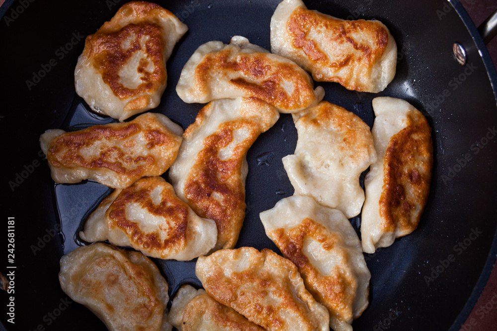 Top view above preparing traditional meal in the frying pan. Old Polish dish pirogi. Food preparing concept image