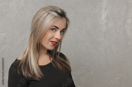 Beautiful girl with red lips and in a black dress. portrait on the background of gray concrete wall. emotion. different poses