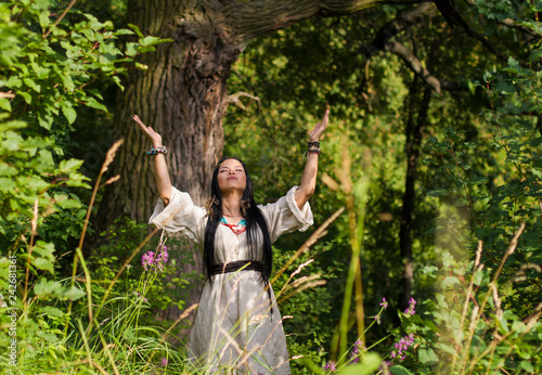 woman shaman conjures in the forest