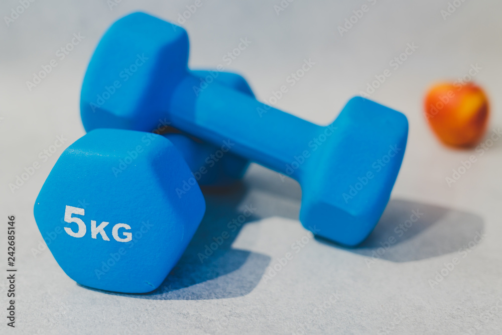 heavy dumbbells on concrete surface with apple heavy dumbbells on concrete surface with apple
