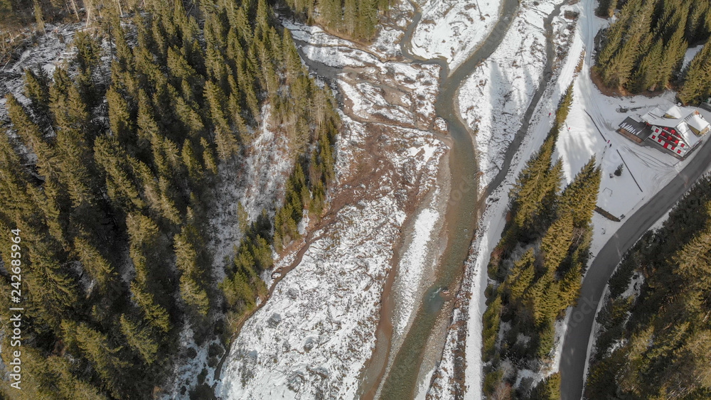 Aerial panoramic view of mountain valley in winter with snow, forest and river Aerial panoramic view of mountain valley in winter with snow, forest and river