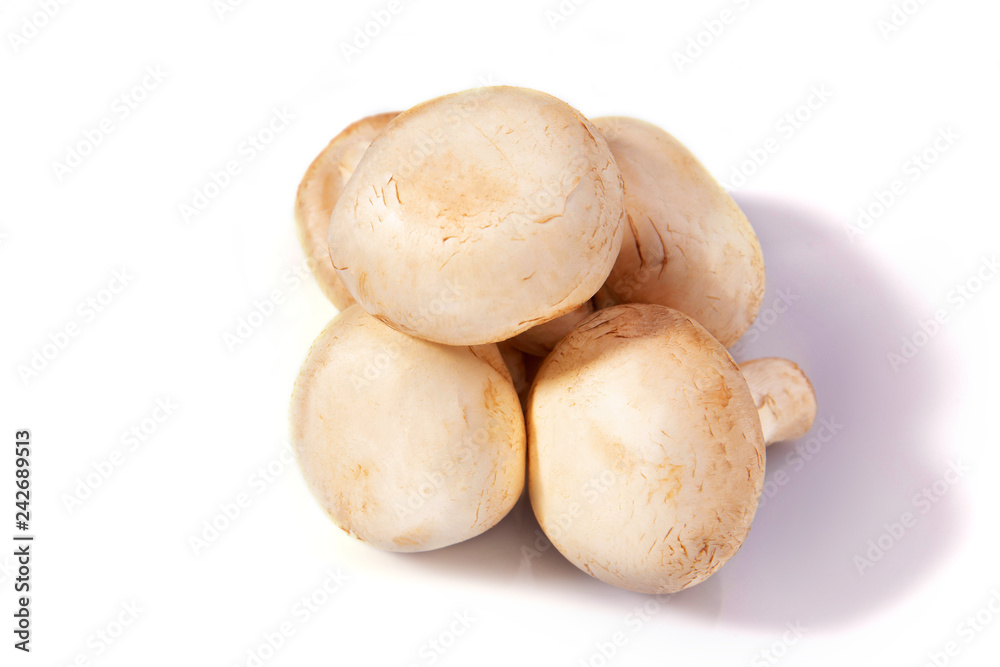 Mushrooms champignons lie on a white isolated background Mushrooms champignons lie on a white isolated background