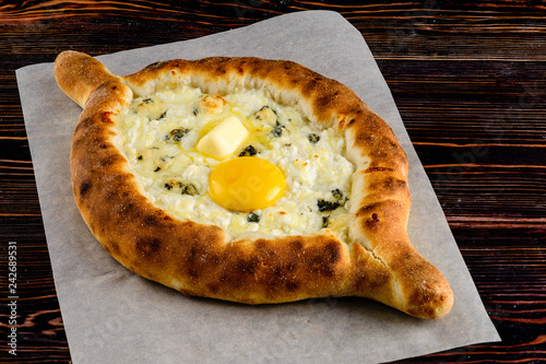 khachapuri adjara traditional Georgian cuisine meal. Baked bread with cheese and egg filling photo