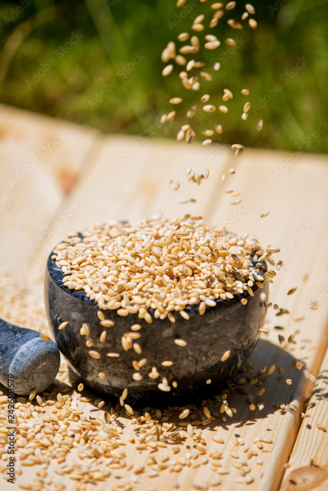 wheat poured into a bowl on a wooden table wheat poured into a bowl on a wooden table