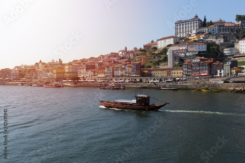 The old town of Porto, and the river Douro, Portugal. Wooden old boat moving by river