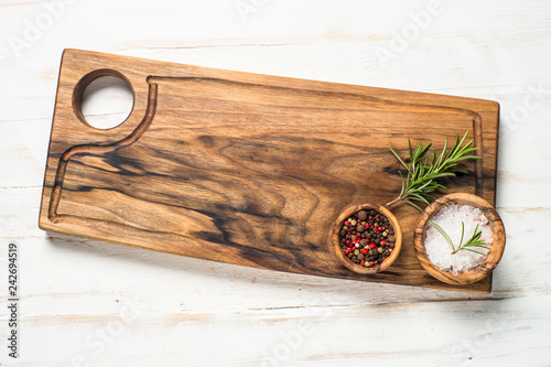 Wooden curring board and spices on white  top view.