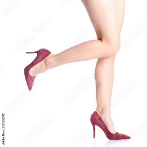 Female legs in red maroon high heel shoes goes on white background. Isolation