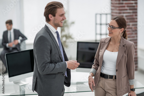 businessman and businesswoman standing in a modern office