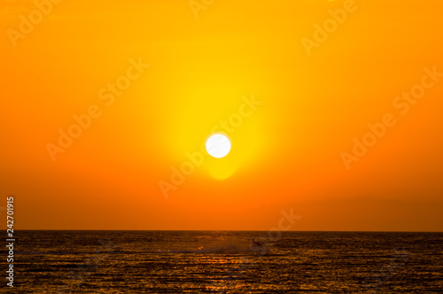 Amazing sea sunset on the pebble beach  the sun  waves  clouds