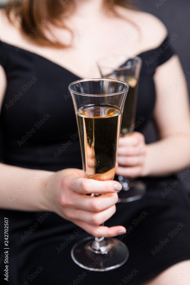 Valentines day romance, beautiful woman holding champagne glasses in hands,close up.