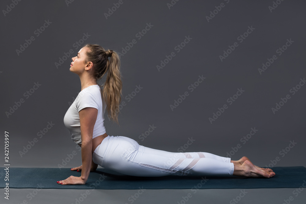 Sporty young woman doing yoga practice on black background. Sporty young woman doing yoga practice on black background.