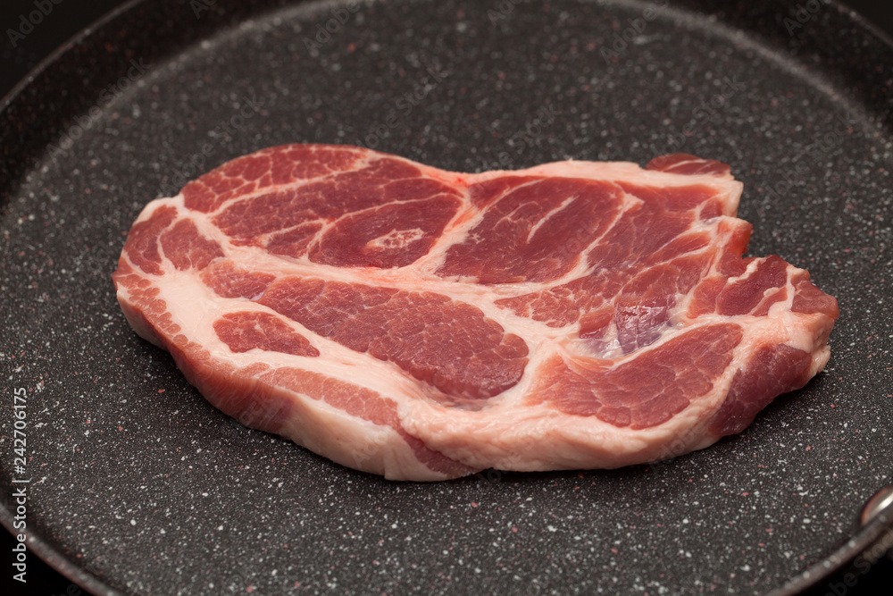 Pork steak in non-stick frying pan Pork steak in non-stick frying pan