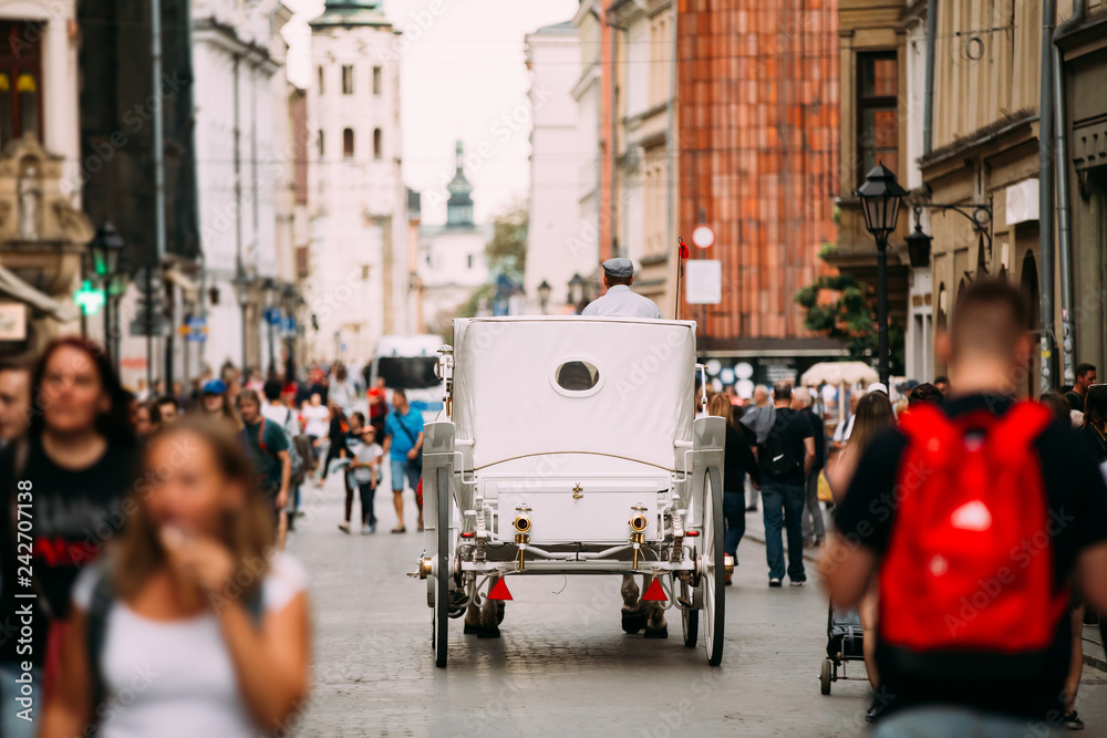 Obraz premium Krakow, Poland. Old-fashioned Coach Carriage Moving At Old Town 