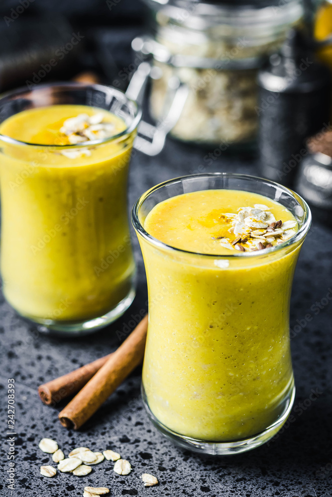 Oatmeal turmeric smoothie on dark background. Selective focus, space for text. Oatmeal turmeric smoothie on dark background. Selective focus, space for text.