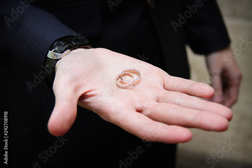 Wedding rings in the hand of the groom. Wedding gold rings on wedding day