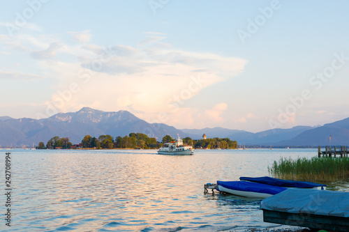 Island Fraueninsel at lake Chiemsee at sunset with sailing boat and ferry