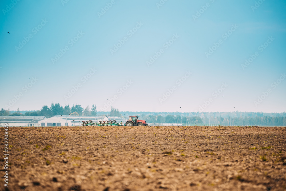 Tractor Plowing Field In Autumn Season Tractor Plowing Field In Autumn Season