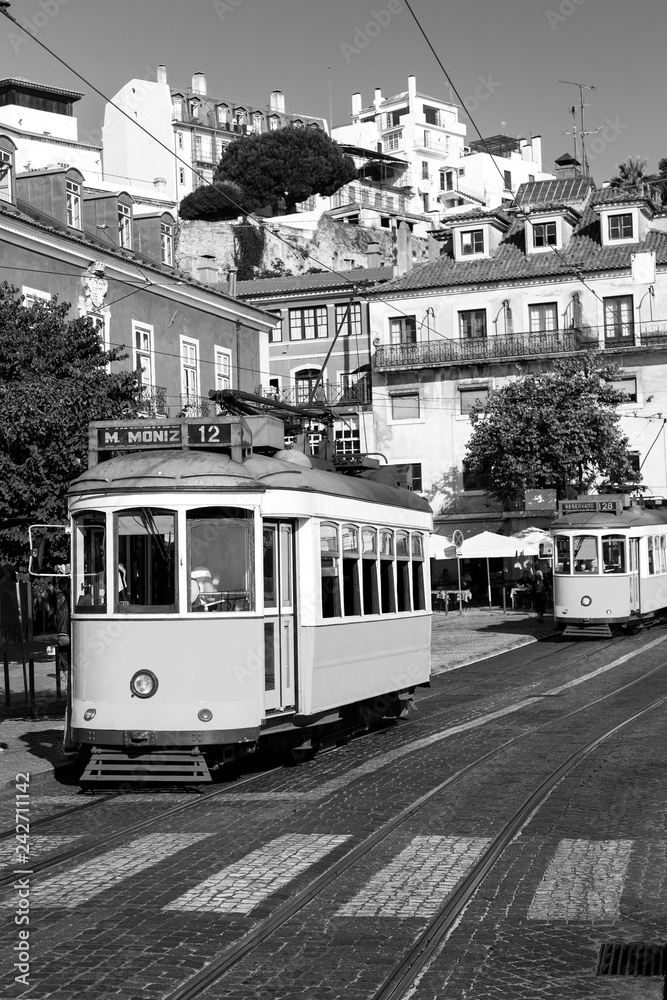 Naklejka premium Black and white picture of a vintage tram on old streets of Lisbon, Alfama, Portugal, popular touristic attraction and destination.