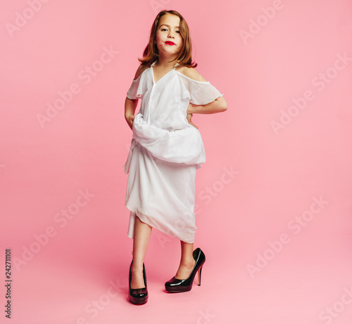 Fotografie Girl pretending she is all grown up in fancy clothes