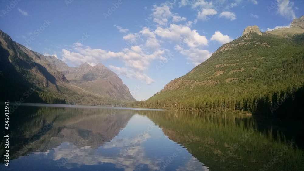 Upper Kintla Lake Glacier National Park in Montana. Beautiful reflection in lake flanked by forest of trees and mountain peaks. Utopian paradise away from cities and crowds very peaceful