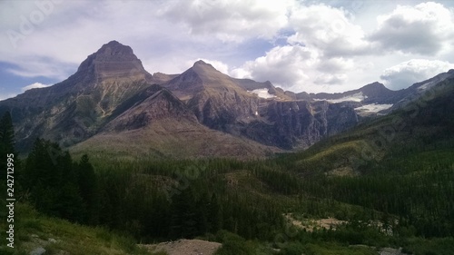Glacier National Park mountains and forest on a clear day with some clouds. Beautiful