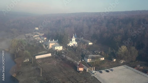 Aerial view of christian monastery surrounded by forest and covered with fog. Thiganesty monastery. Moldova republic of. photo