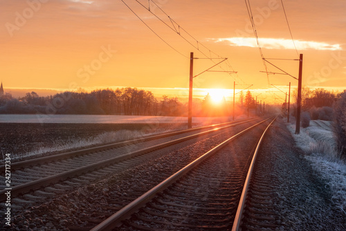 Railroad tracks at sunrise in winter. Travel context. Industrial landscape.