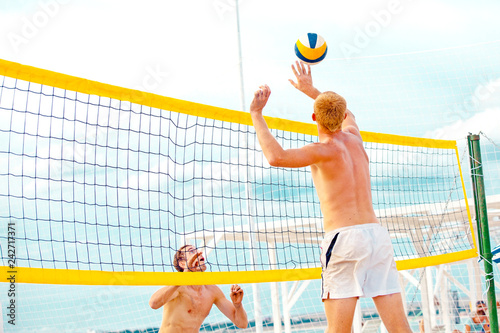 Volleyball beach player is a male athlete volleyball player getting ready to serve the ball on the beach.