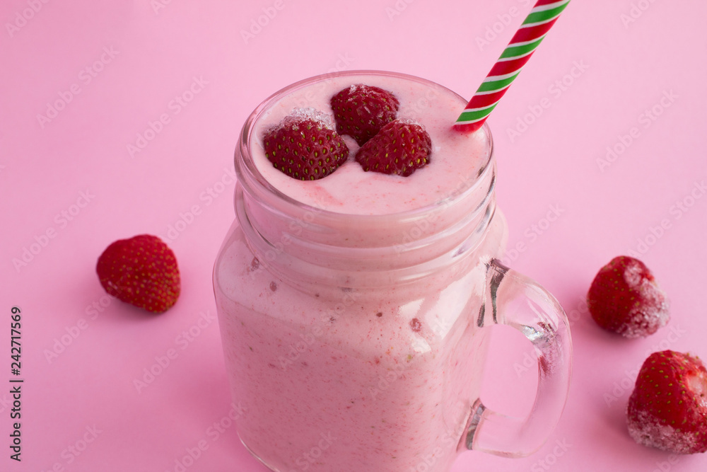Smoothies with yogurt and frozen strawberry on the pink background.Closeup. Smoothies with yogurt and frozen strawberry on the pink background.Closeup.