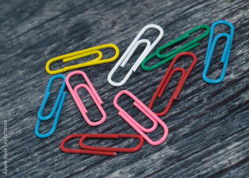 multicolored paper clips on a wooden table, blank for designers multicolored paper clips on a wooden table, blank for designers