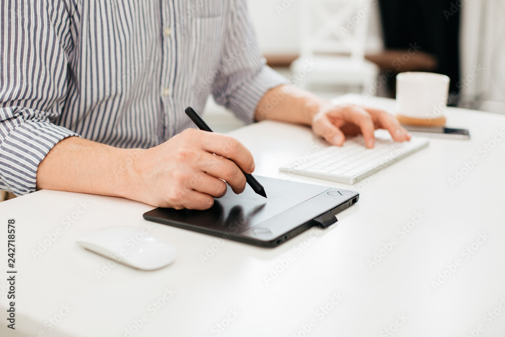 Close up of drawing tablet and man holding stylus Close up of drawing tablet and man holding stylus