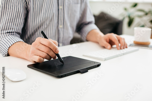 Close up of person using stylus on graphic tablet