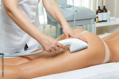 Fotografie Cosmetologist performs vacuum roller massage   procedure for hips and but in cos