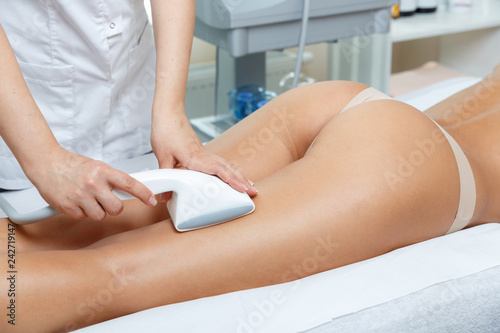 Cosmetologist performs vacuum roller massage   procedure for hips and but in cosmetological clinic