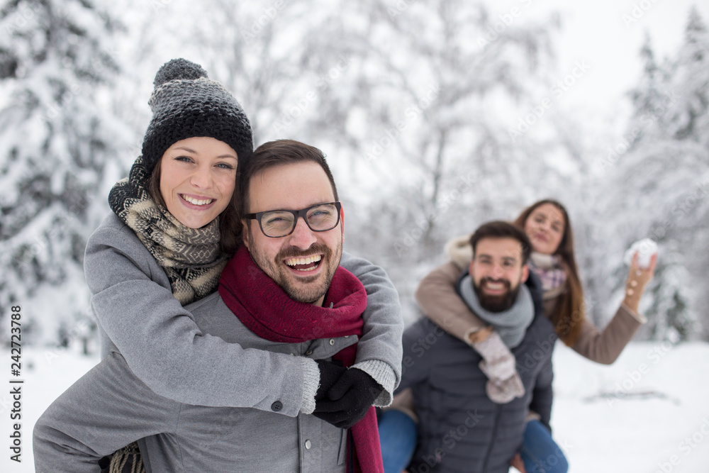 Two couples playing on snow Two couples playing on snow