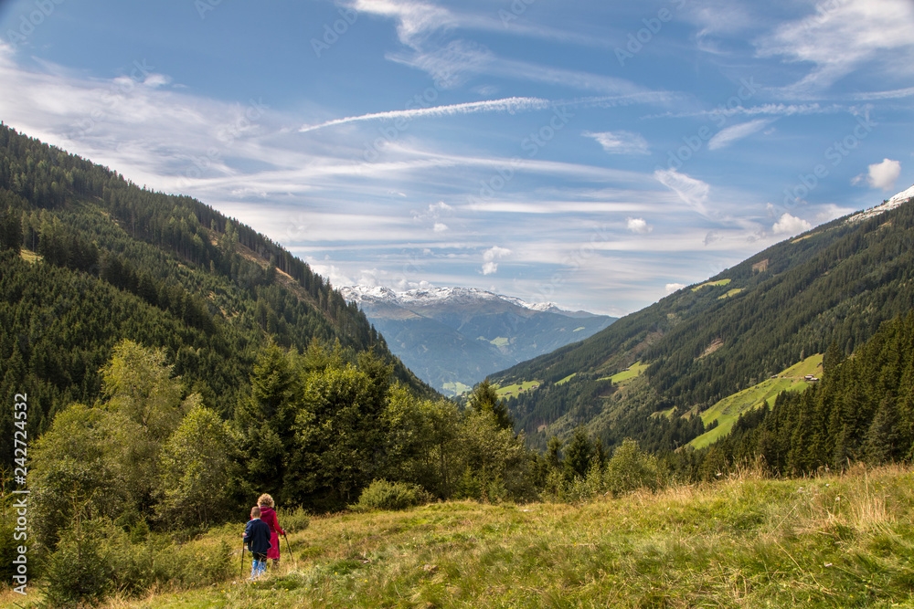 Fototapeta premium Woman standing on a footpath with a magnificent view - view from behind