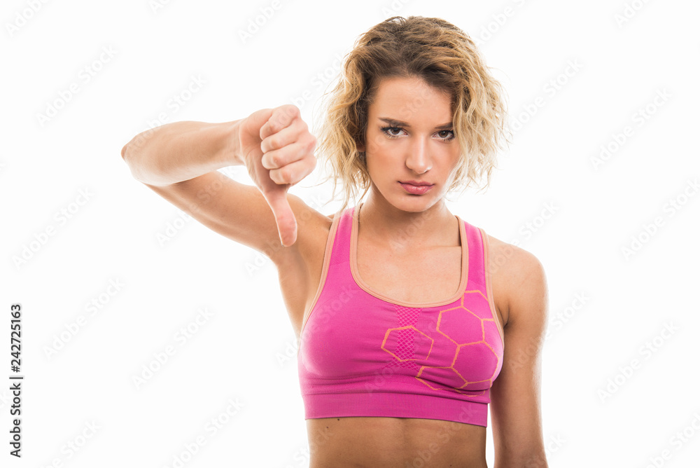 Portrait of beautiful young fit girl showing thumb down Portrait of beautiful young fit girl showing thumb down