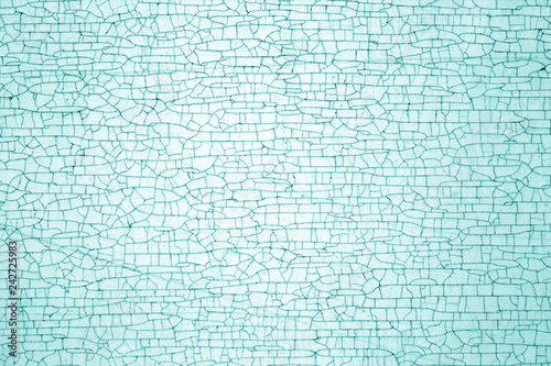 Cracks on metal colored texture in cyan tone.
